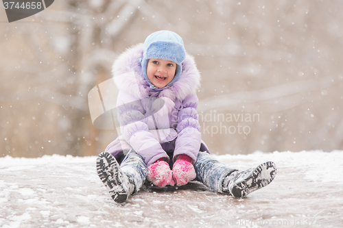 Image of Joyful child slides down the icy hill