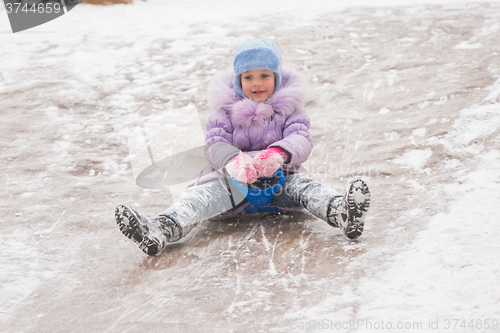 Image of Five-year girl rolls on in the middle of the ice slides