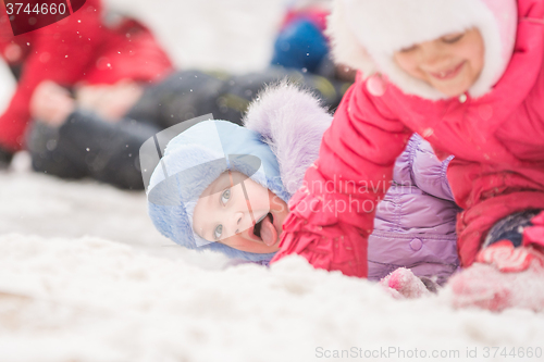 Image of Girl showing tongue rolled down a hill and fell into the snow