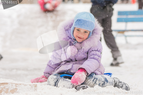 Image of Joyful five years girl has slipped from the icy hill