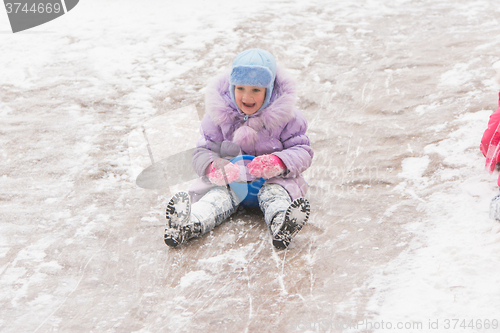 Image of  Five-year girl in the middle of the ice slides slides