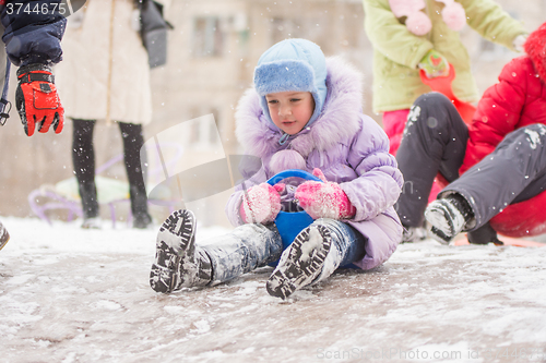 Image of Five-year girl is rolling a frozen hill