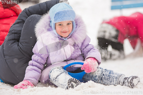 Image of Five-year girl rolled down a hill sits 