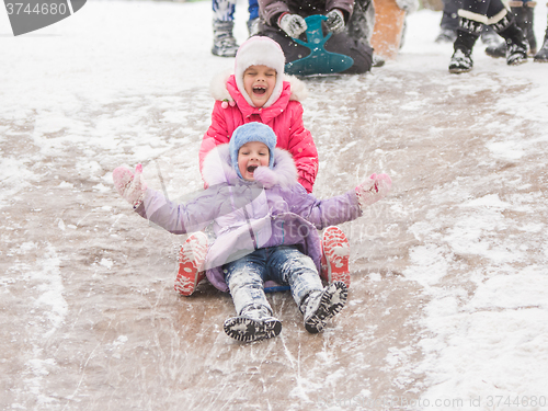 Image of Two cheerful girls ride a roller coaster of ice