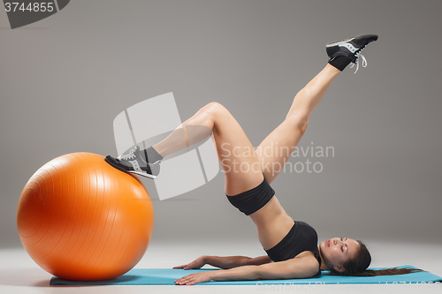 Image of The young, beautiful, sports girl doing exercises on a fitball 