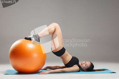 Image of The young, beautiful, sports girl doing exercises on a fitball 