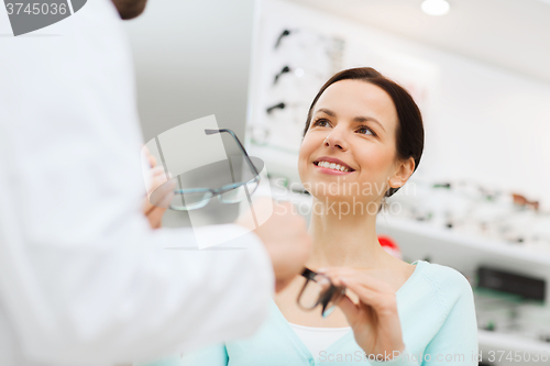 Image of woman and optician showing glasses at optics store