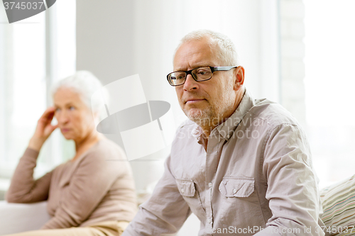 Image of senior couple sitting on sofa at home