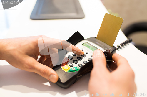 Image of hand entering pin code to bank terminal