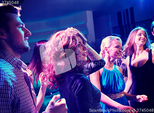 Image of smiling friends dancing in club