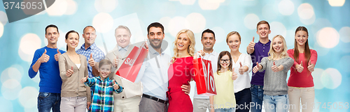 Image of happy people with shopping bags showing thumbs up