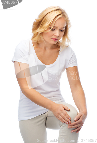 Image of unhappy woman suffering from pain in leg