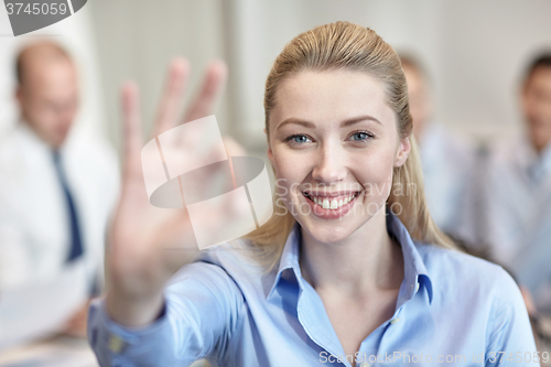 Image of group of smiling businesspeople meeting in office