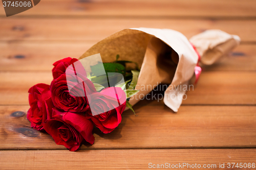 Image of close up of red roses bunch wrapped into paper