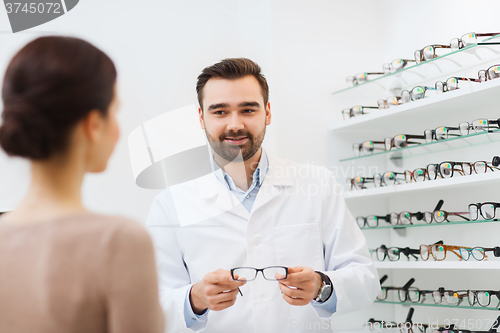 Image of woman and optician showing glasses at optics store