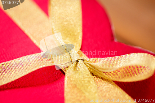 Image of close up of red heart shaped gift box with bow