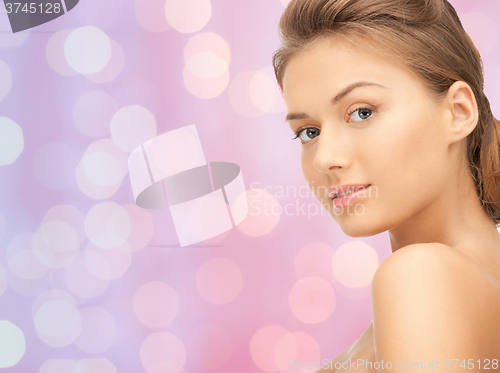 Image of lovely woman face over pink lights background
