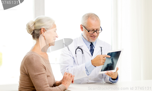 Image of smiling senior woman and doctor with tablet pc