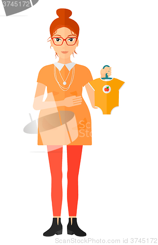 Image of Pregnant woman with clothes for baby.