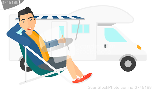 Image of Man sitting in front of motorhome.