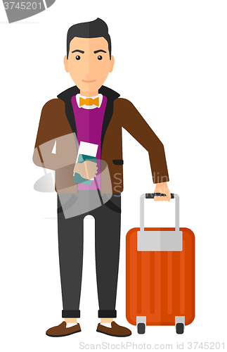 Image of Man standing with suitcase and holding ticket.