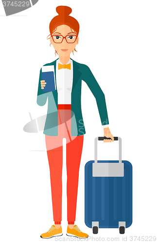 Image of Woman standing with suitcase and holding ticket.