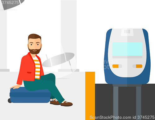 Image of Man sitting on railway platform.
