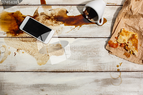 Image of Cup of coffee spilled on wooden table