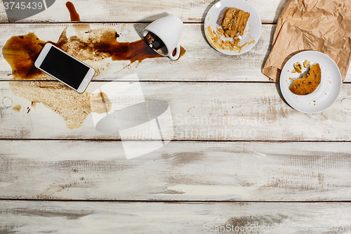 Image of Cup of coffee spilled on wooden table