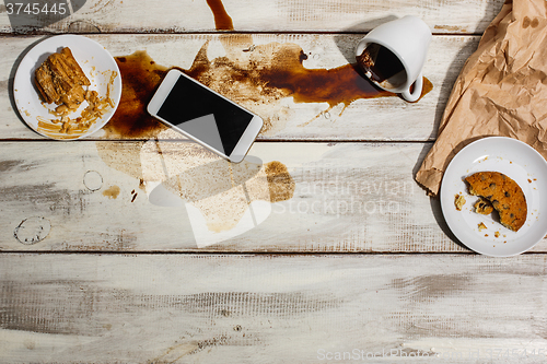 Image of Cup of coffee spilled on wooden table