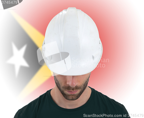 Image of Engineer with flag on background - East Timor