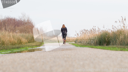 Image of Young woman walking in a dutch landscape