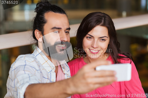 Image of couple taking selfie by smartphone at restaurant