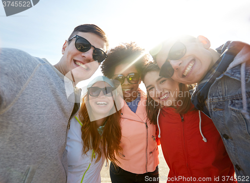 Image of smiling friends taking selfie