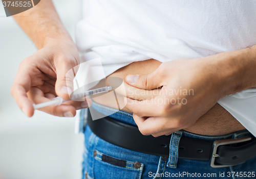 Image of man with syringe making insulin injection