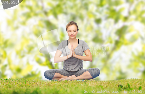 Image of woman making yoga meditation in lotus pose on mat