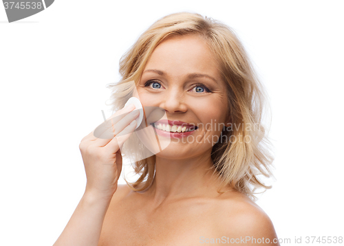 Image of happy woman cleaning face with cotton pad