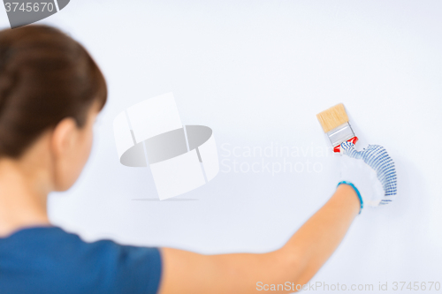 Image of woman with paintbrush colouring the wall