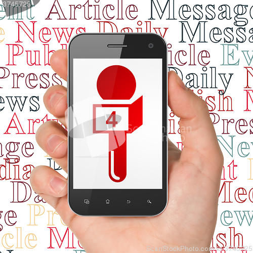 Image of News concept: Hand Holding Smartphone with Microphone on display