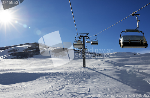 Image of Chair-lift and blue sky with sun