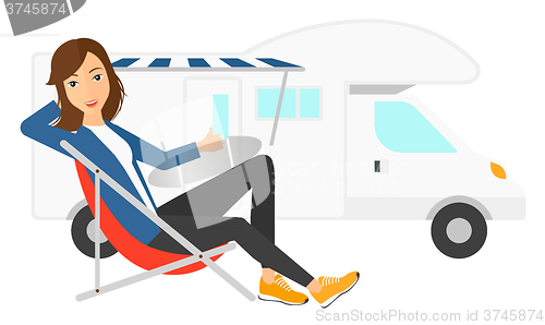Image of Woman sitting in front of motorhome.