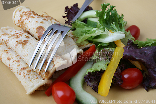 Image of Salad and pancakes with fork