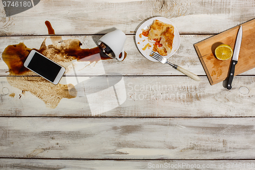 Image of Cup of coffee spilled on wooden table