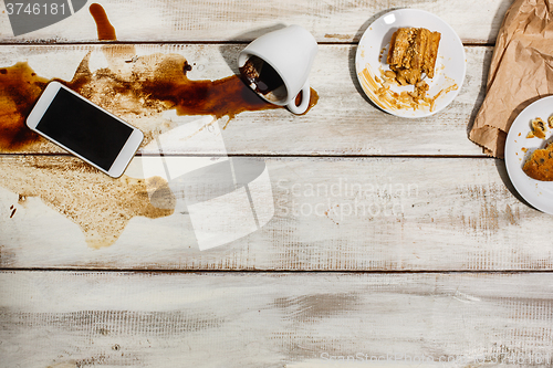 Image of Cup of coffee spilled on wooden table