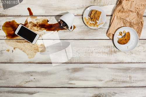 Image of Cup of coffee spilled on wooden table