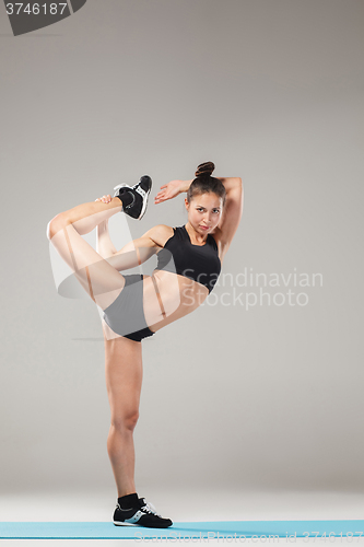 Image of Beautiful sporty girl standing in acrobat pose or yoga asana