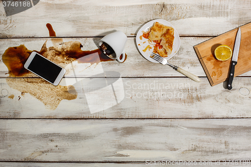 Image of Cup of coffee spilled on wooden table