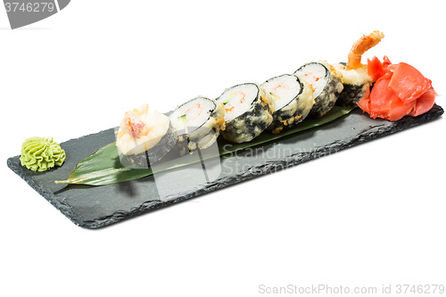 Image of set of sushi on black slate substrate, isolated white background