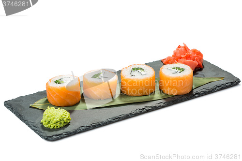 Image of set of sushi on black slate substrate, isolated white background