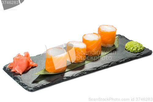 Image of set of sushi on black slate substrate, isolated white background